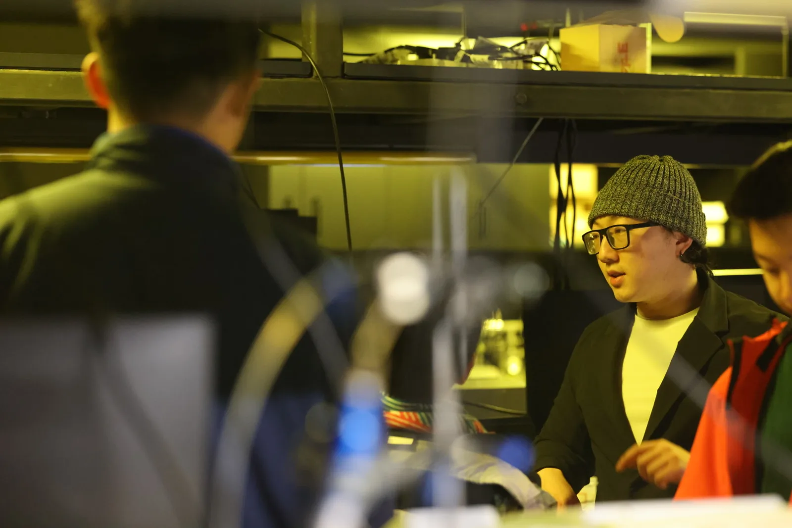 A mentor discussing the hook design beside the 3D printers