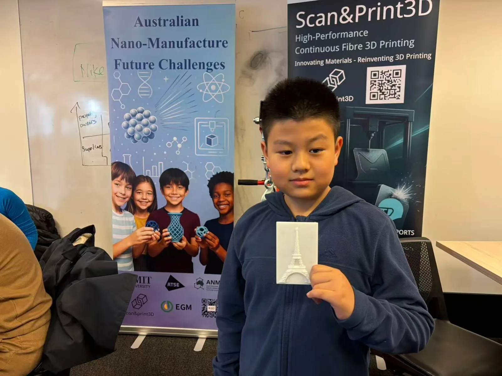 A student holding a 3D printed Eiffel Tower model at the Event