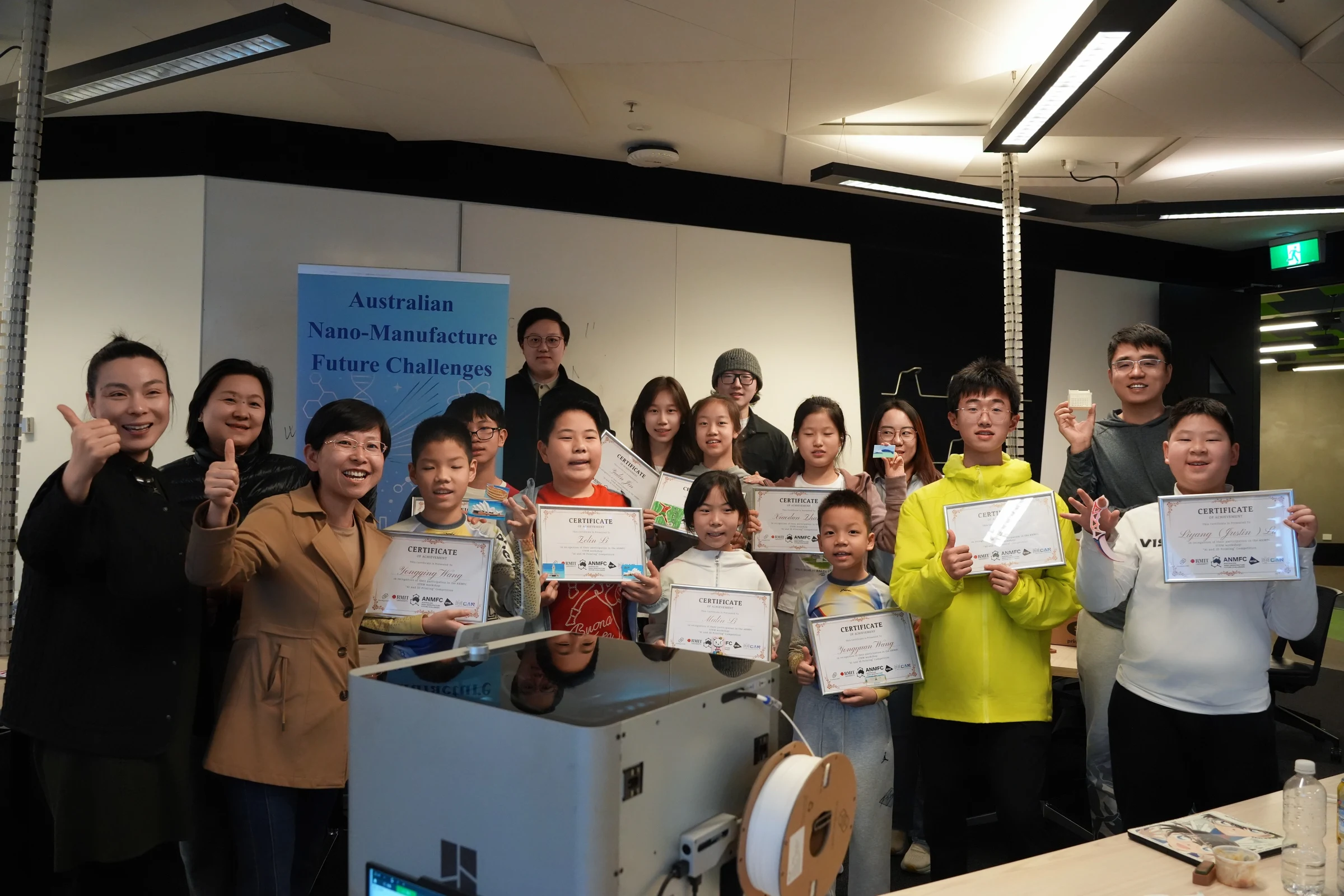 Participants holding certificates beside a 3D printer after the Hook Challenge