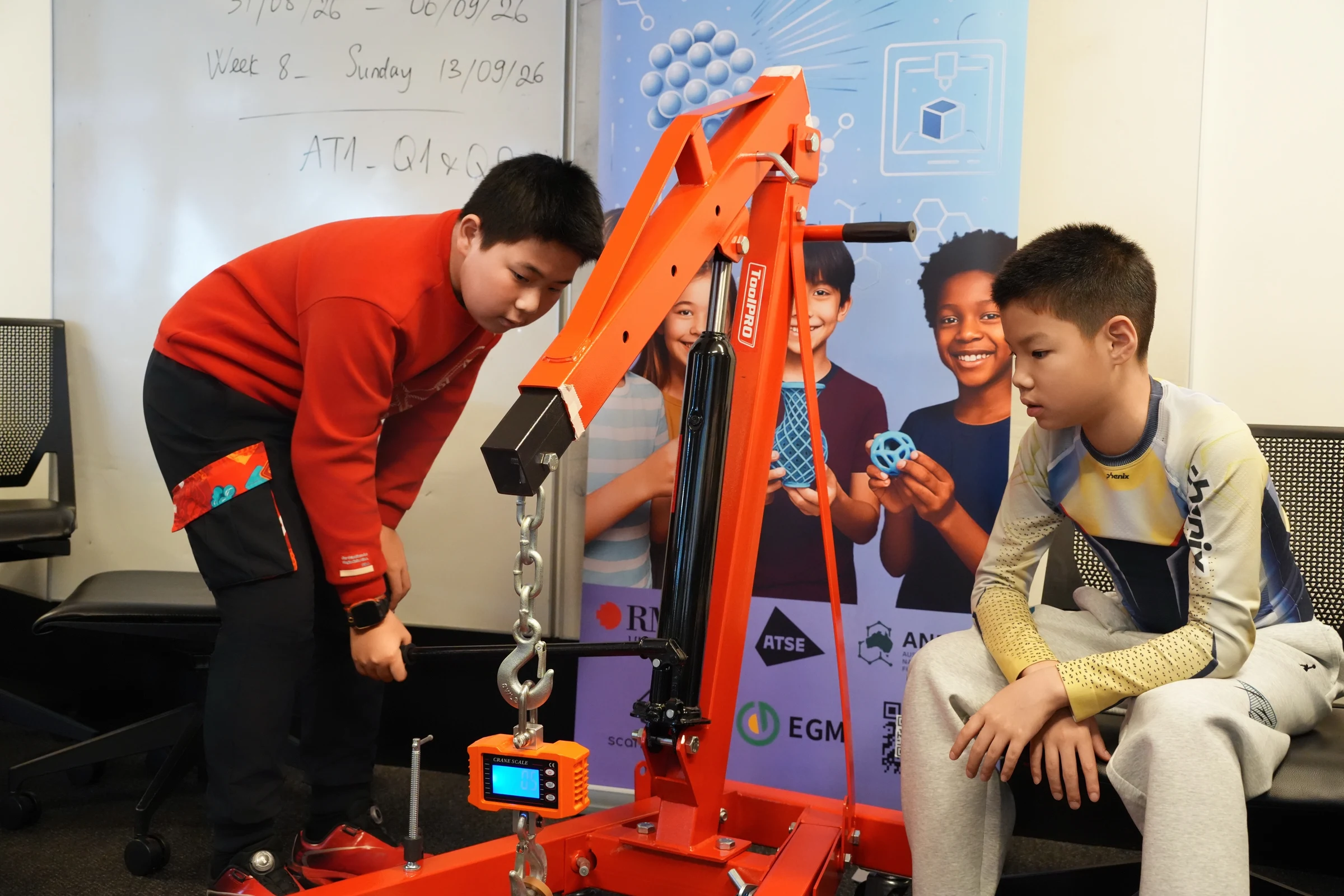 Two students watching a crane scale during the load-bearing test