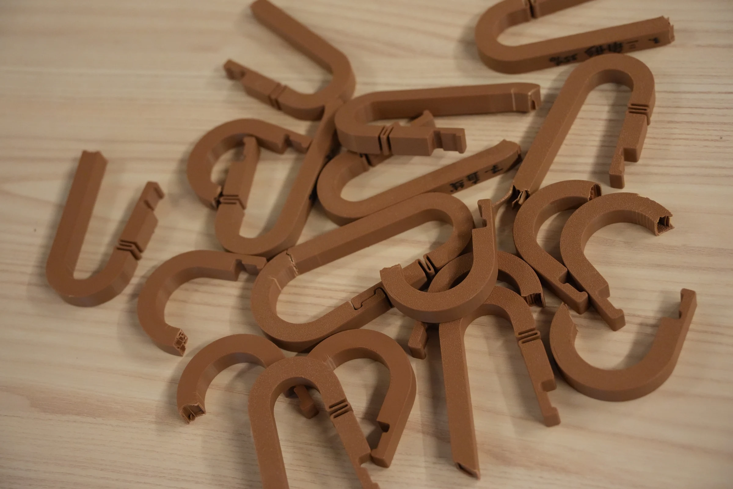 A collection of 3D printed load-bearing hooks on a table