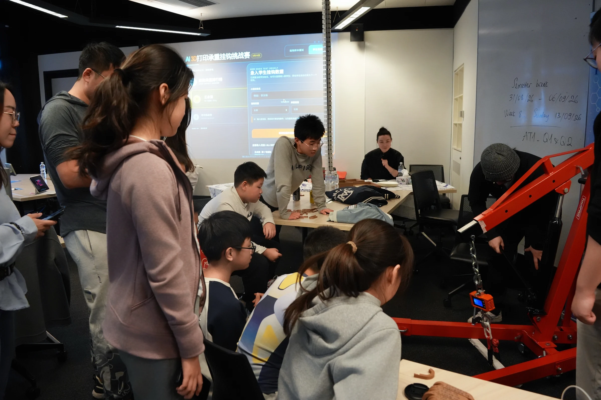 Participants around the hook challenge screen and load-test crane